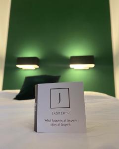 a book on a bed with a sign on it at Jasper's Boutique Hotel in Berlin