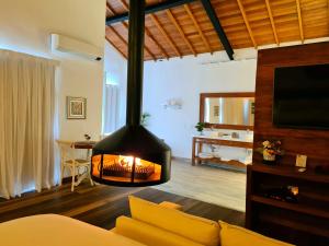 a living room with a fireplace and a couch at Pousada Serra da Índia in Penedo