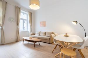 salon ze stołem i kanapą w obiekcie Modernes Apartment im charmanten Cottage Viertel w Wiedniu