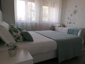 two beds in a room with two windows at Bed da Anna in Peschiera del Garda