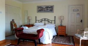 a bedroom with a large bed and a chair at Newlands Lodge in Kilkenny