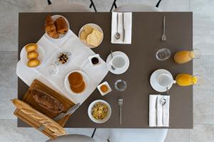 a table with a bunch of breakfast foods on it at HOTEL LE 25 in Andernos-les-Bains