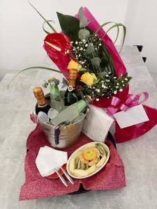 un bouquet de fleurs et de vin et une assiette de nourriture dans l'établissement IsolaDino b&b sweet home, à Praia a Mare