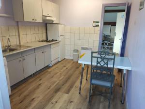 a kitchen with a table and a chair in it at LES TILLEULS in Bains-les-Bains