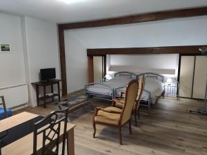 a bedroom with a bed and a table and chairs at LES TILLEULS in Bains-les-Bains
