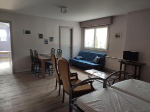 a living room with a blue couch and a table at LES TILLEULS in Bains-les-Bains