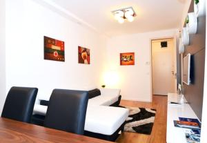 a living room with a white couch and black chairs at Apartment Trnje in Zagreb