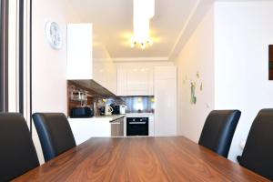 une table à manger avec des chaises noires et une cuisine dans l'établissement Apartment Trnje, à Zagreb