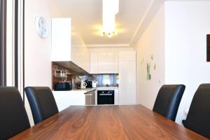 a dining room table with black chairs and a kitchen at Apartment Trnje in Zagreb