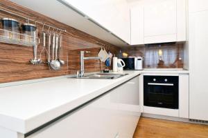 a kitchen with white cabinets and a sink at Apartment Trnje in Zagreb