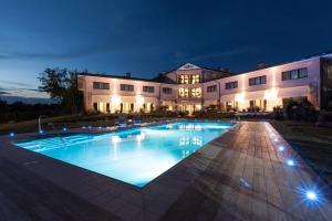 a large house with a swimming pool at night at Hotel Al Ponte in Gradisca dʼIsonzo