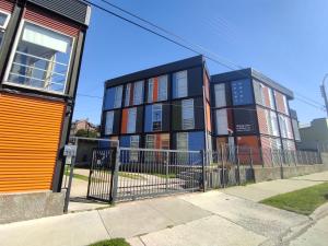 un edificio in una strada con recinzione di Apart Hotel Quillango a Punta Arenas