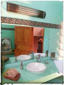 Baño con 2 lavabos frente a un espejo en Riad El Bir, en Rabat