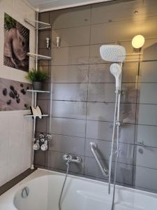 y baño con ducha y bañera con cabezal de ducha. en bel-appartement-avec-terrasse, en Bad Schwartau