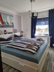 a bedroom with two beds with blue curtains and a window at bel-appartement-avec-terrasse in Bad Schwartau