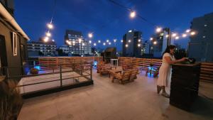 a woman standing on top of a balcony at night at Vida, hotel de playa in Puerto Madryn