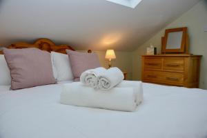 a bedroom with a white bed with towels on it at Forge Cottage, Helmsley in Helmsley