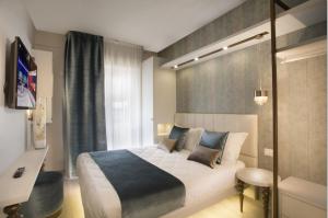 Un dormitorio con una gran cama blanca y una ventana en Hotel Ambassador, en Riccione