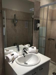 La salle de bains est pourvue d'un lavabo blanc et d'une douche. dans l'établissement Villa 418, à Saint-Raphaël