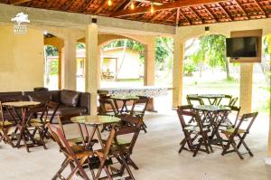 a living room with tables and chairs and a couch at Pousada Marajó in Salvaterra