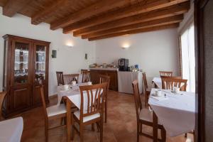a dining room with white tables and wooden chairs at Agriturismo Corte Rondinella in Verona