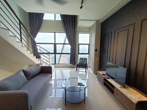 a living room with a couch and a glass table at Nj Homestay at Arte Mont Kiara in Kuala Lumpur