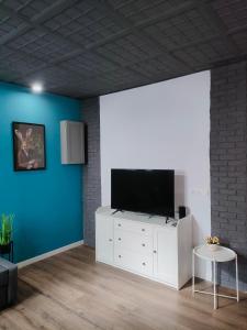 una sala de estar con TV de pantalla plana en un armario blanco en LoL apartment, en Alicante