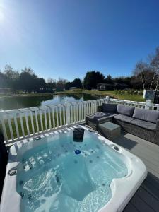 une baignoire jacuzzi installée au-dessus d'une terrasse dans l'établissement Lakeside Retreat Lodge With Hot Tub, à Pocklington