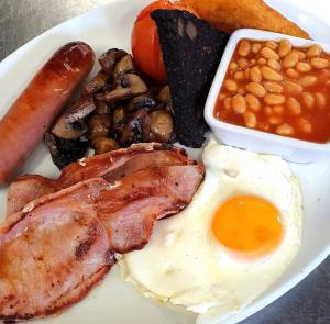 um prato de comida com um ovo, bacon, feijão e uma salsicha em The Fylingdales Inn em Whitby