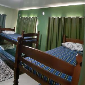 2 beliches num quarto com paredes verdes em Vida Linda Hostel em Pitimbu