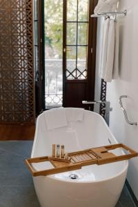 a white bath tub in a bathroom with a window at Alhambra Palace Hotel in Granada +73 photos