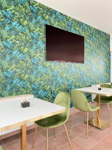 a room with tables and chairs and a tv on a wall at Hotel Palladium Palace in Rome