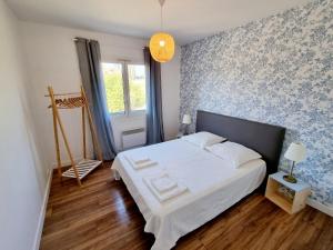 una camera con letto e parete blu e bianca di Bel appartement centre ville 3 chambres a Saint-Florent