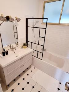 a bathroom with a sink and a tub and a mirror at Bel appartement centre ville 3 chambres in Saint-Florent