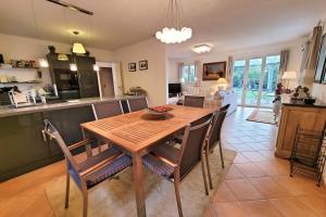 een keuken en eetkamer met een houten tafel en stoelen bij Beautiful House For 8 With Garden And Pool in Saint-Cyr-sur-Mer