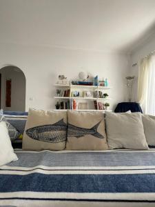 un sofá con almohadas en la sala de estar en Amarguinha, en Burgau