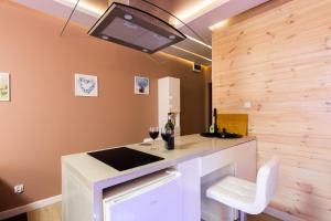 a kitchen with a bar with a sink and wine glasses at Melody De Luxe Apartment in Michałowice