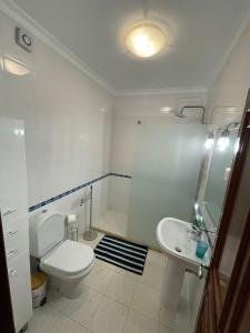een witte badkamer met een toilet en een wastafel bij Amarguinha in Burgau