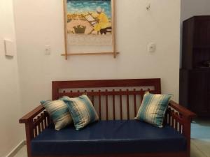 un banco con dos almohadas en una habitación en Chalé Pitanga, en São Miguel do Gostoso