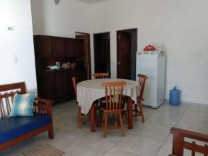 une cuisine avec une table, des chaises et un réfrigérateur dans l'établissement Chalé Pitanga, à São Miguel do Gostoso 31 autres photos