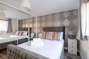 a bedroom with two beds and a mirror at Stunning 1 Bed at Holyrood Palace & Arthurs Seat in Edinburgh