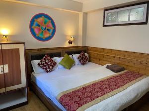 um quarto com uma cama grande com almofadas em Magnolia Residency em Darjeeling