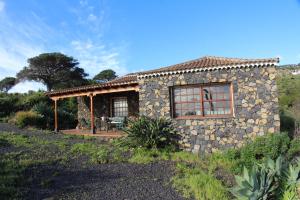 a stone house with a patio in a field at Casa Las Caracolas in Mazo