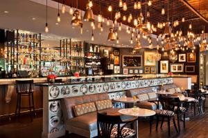 a restaurant with a bar with tables and chairs at Hotel ZaZa Dallas in Dallas