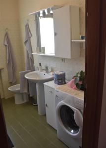 y baño con lavadora y lavamanos. en CASA CARLOTTA (Cipat 022104-AT-010301) en Levico Terme