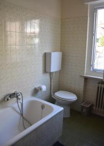 baño con bañera, aseo y ventana en CASA CARLOTTA (Cipat 022104-AT-010301) en Levico Terme