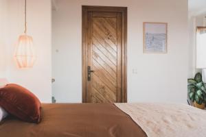 a bedroom with a bed with a wooden door at SwellHouse in Tamraght Ouzdar