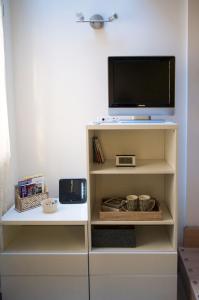 un televisor sentado en la parte superior de un estante blanco en Via de' Falegnami 6 Apartment by Wonderful Italy, en Bolonia