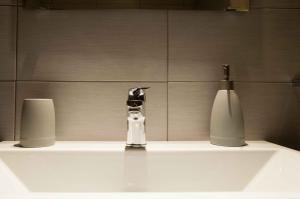 lavabo con grifo y jarrón en Via de' Falegnami 6 Apartment by Wonderful Italy, en Bolonia