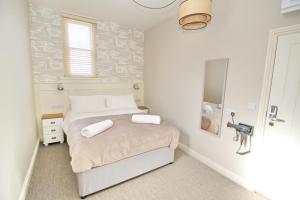 een kleine slaapkamer met een bed en een badkamer bij CarterCo Rooms in Portsmouth